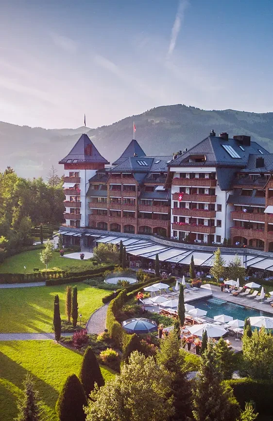 The Alpina Gstaad facade overlooking its garden and outdoor pool