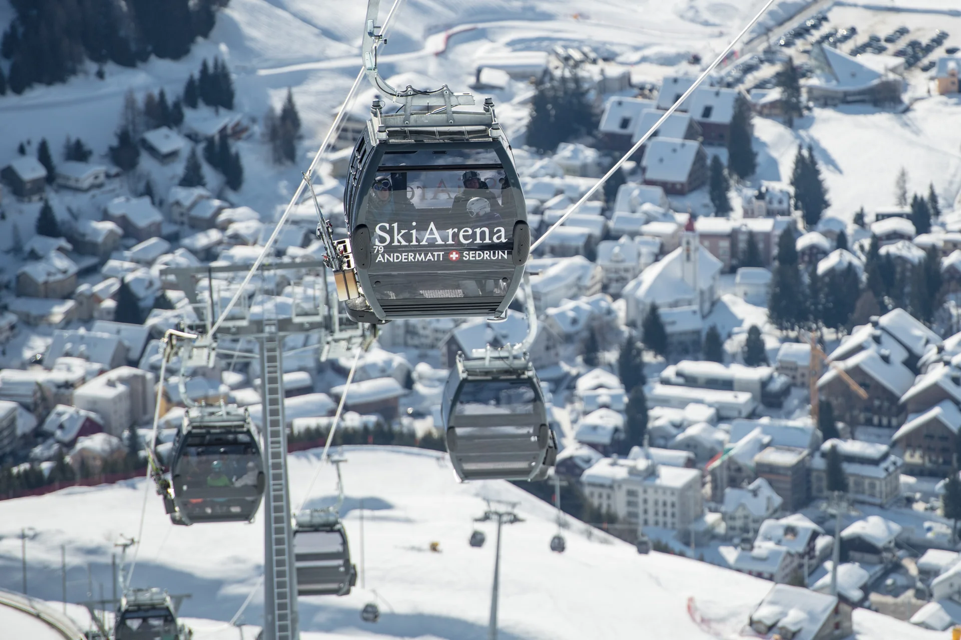 Andermatt SkiArena gondola above the snow-covered village of Andermatt