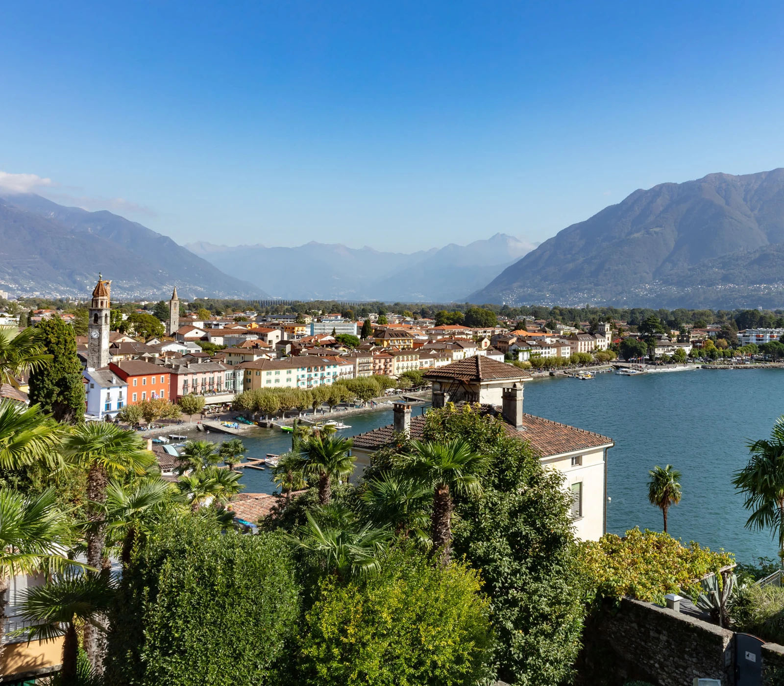 Ascona waterfront and historic centre beside Lake Maggiore with palm trees and mountains