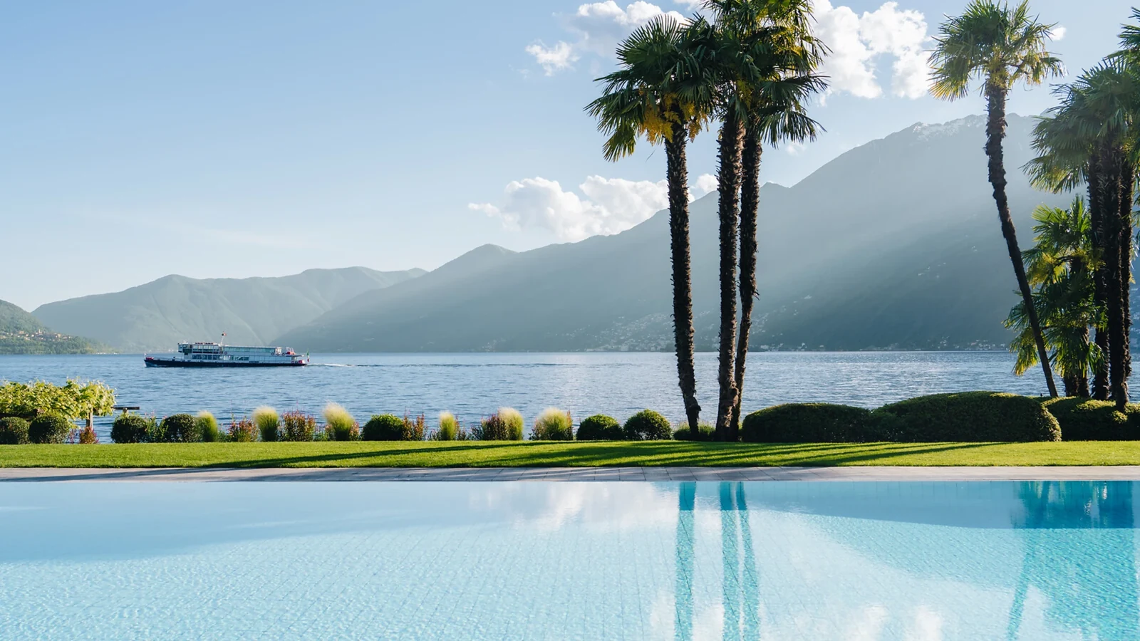 Pool, palm trees and Lake Maggiore at Hotel Eden Roc Ascona