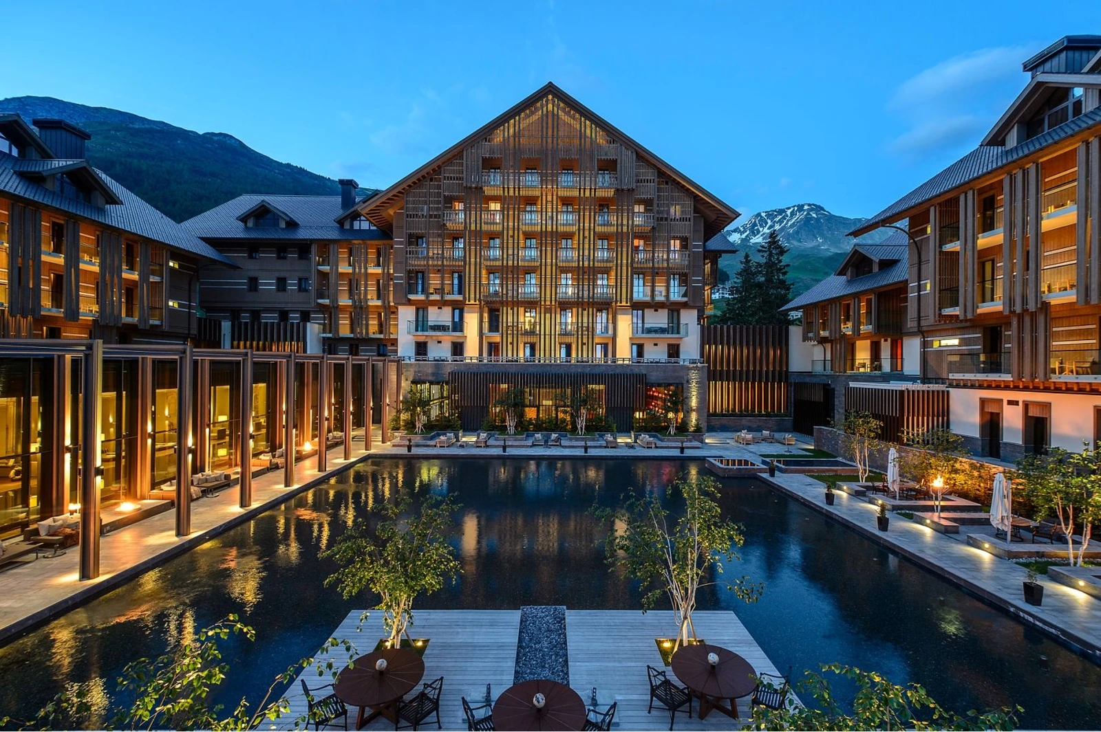 The complete Chedi Andermatt hotel with central facade, surrounding wings and reflecting pool