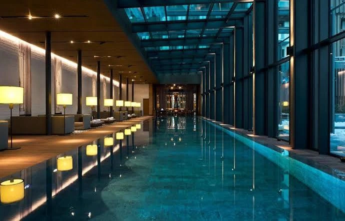 The Chedi Andermatt indoor spa pool with architectural lighting and mountain-facing windows