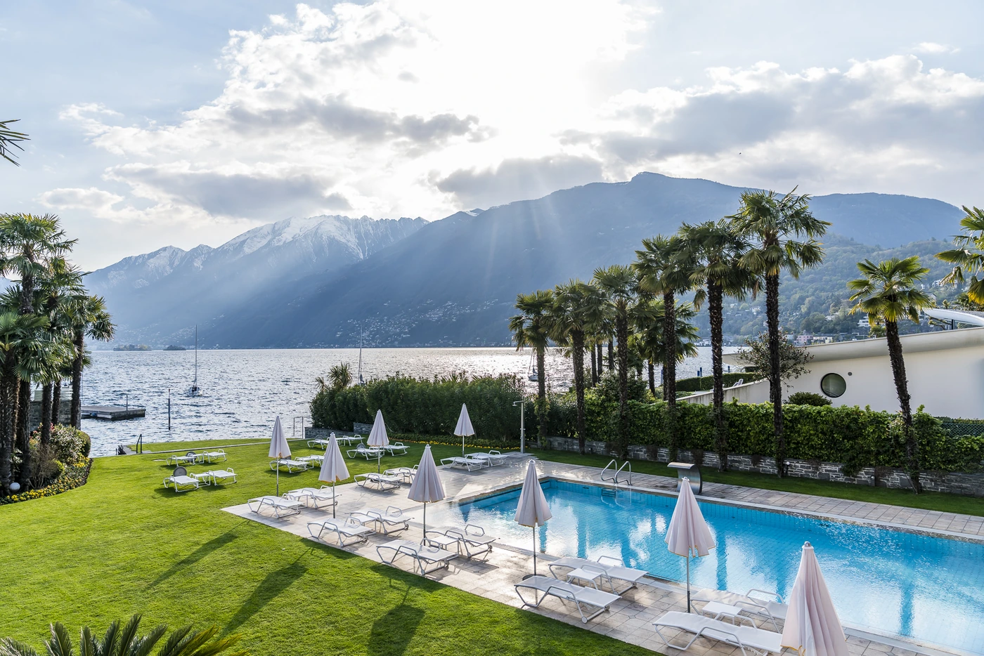Pool, palm garden and Lake Maggiore at Hotel Eden Roc Ascona