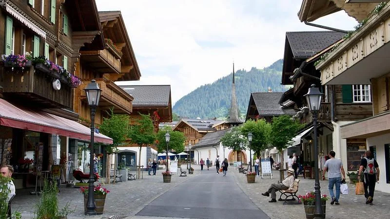 Gstaad promenade with chalet architecture, village church and Alpine surroundings