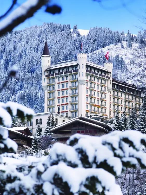 Gstaad Palace with its characteristic towers in the winter landscape