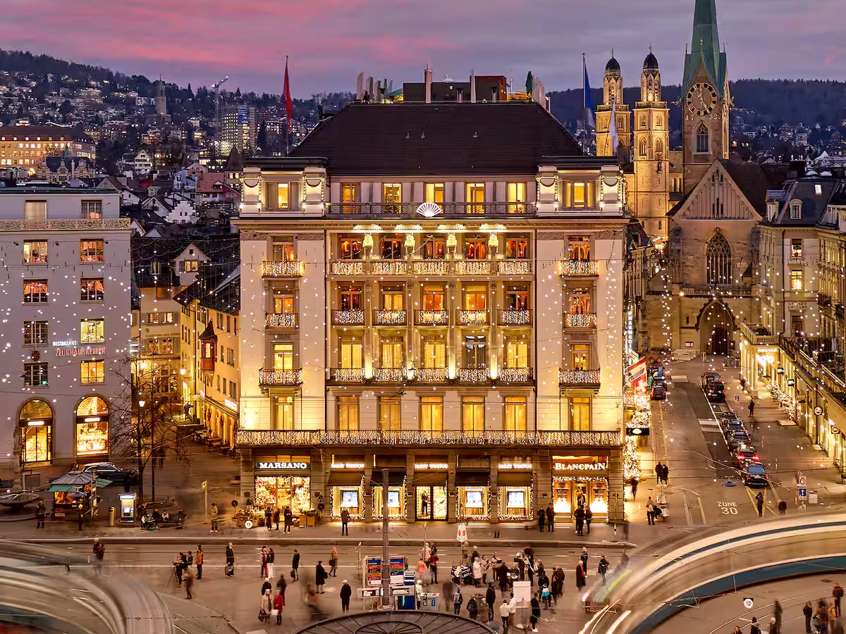 Mandarin Oriental Savoy, Zurich illuminated at Paradeplatz with Zurich church towers beyond