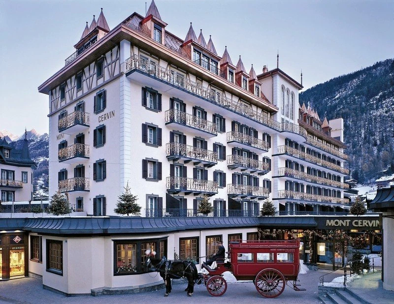 Mont Cervin Palace facade with its hotel name and horse-drawn carriage in car-free Zermatt
